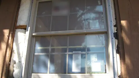 Newly installed double-hung replacement window with fresh exterior trim