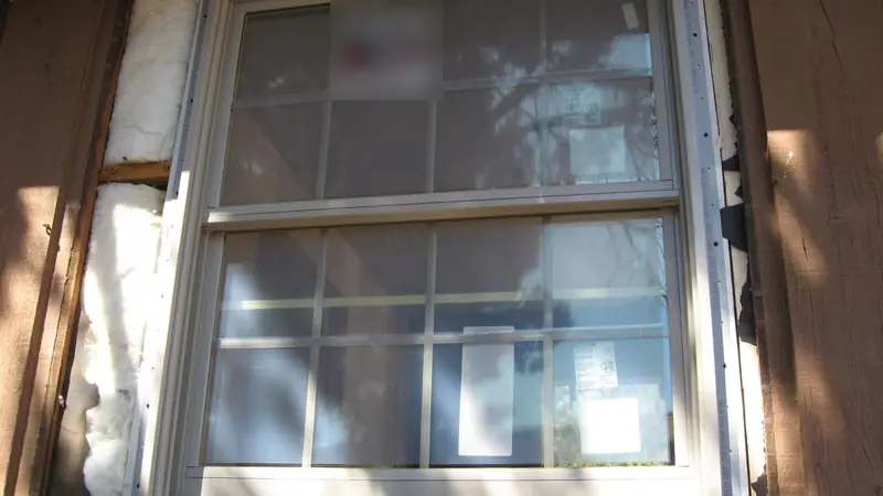 Newly installed double-hung replacement window with fresh exterior trim